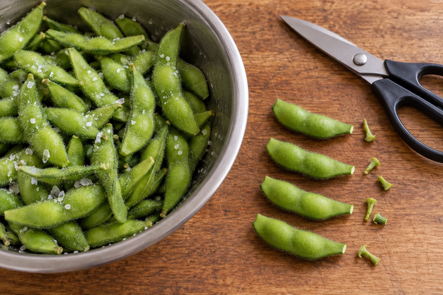 Fresh edamame rubbed with salt beside pods with their small ends trimmed