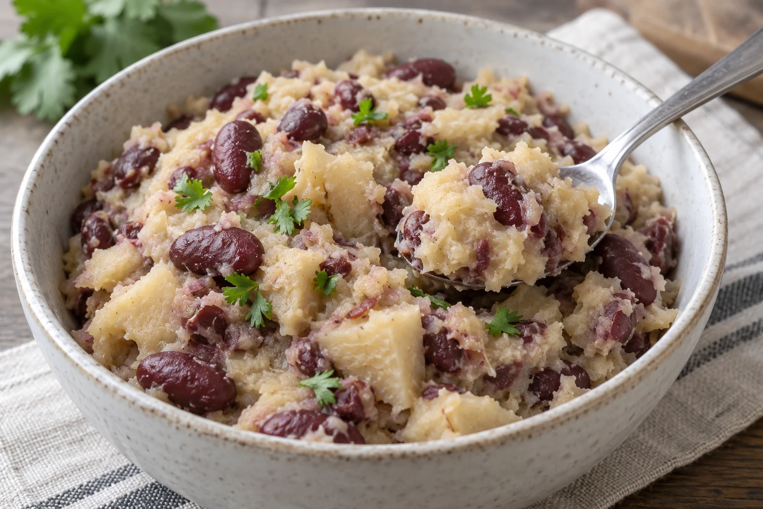 A spoonful of rustic sweet potato and bean mash with a little chopped coriander