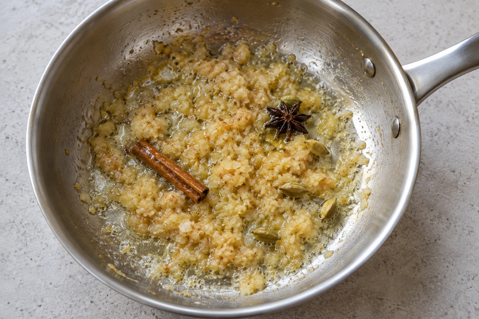 Pale golden aromatic paste with cinnamon, star anise and cardamom in a pan